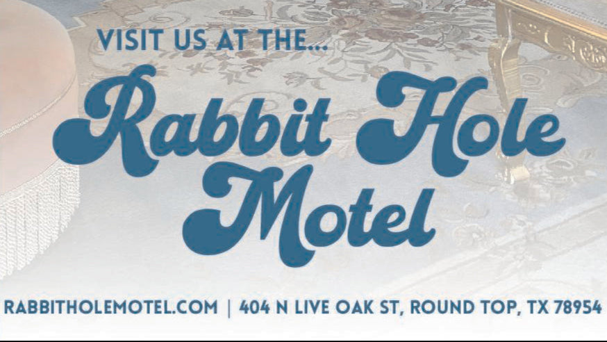 Neon sign and interior of a motel room with 'Down the Rabbit Hole' text.